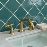 Gold faucet and handles on a marble countertop with teal tiled wall