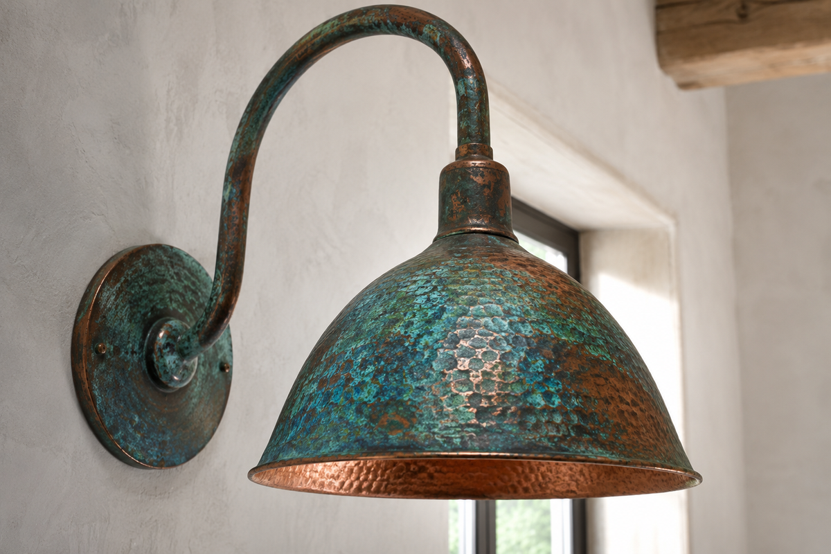 Hand-hammered copper wall sconce showing natural blue-green verdigris patina