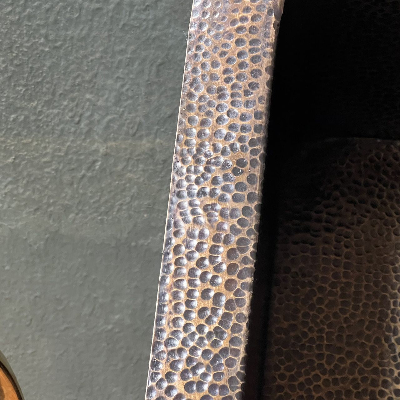 Close-up of a textured metal strip on a dark surface