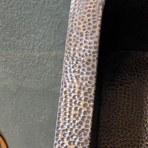 Close-up of a textured metal strip on a dark surface