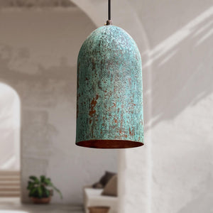 Rustic pendant light with a textured green and brown finish hanging in a room.