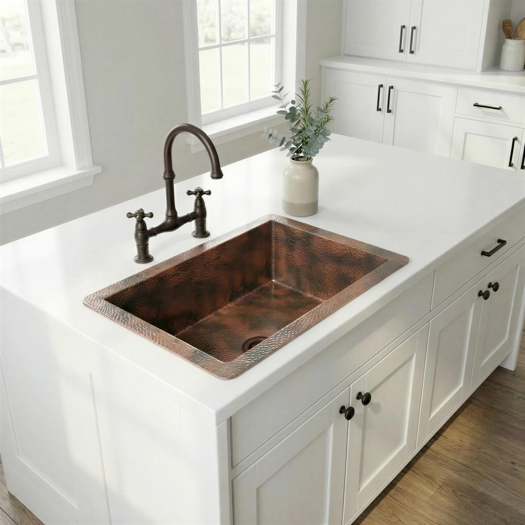 Copper kitchen sink with bronze faucet in a bright kitchen setting
