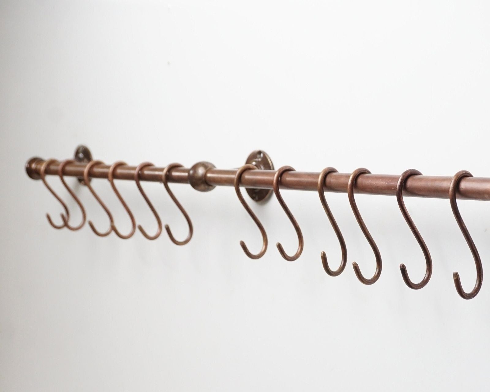 Copper curtain rod with hooks on a white background