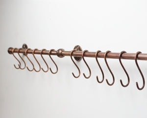 Copper curtain rod with hooks on a white background