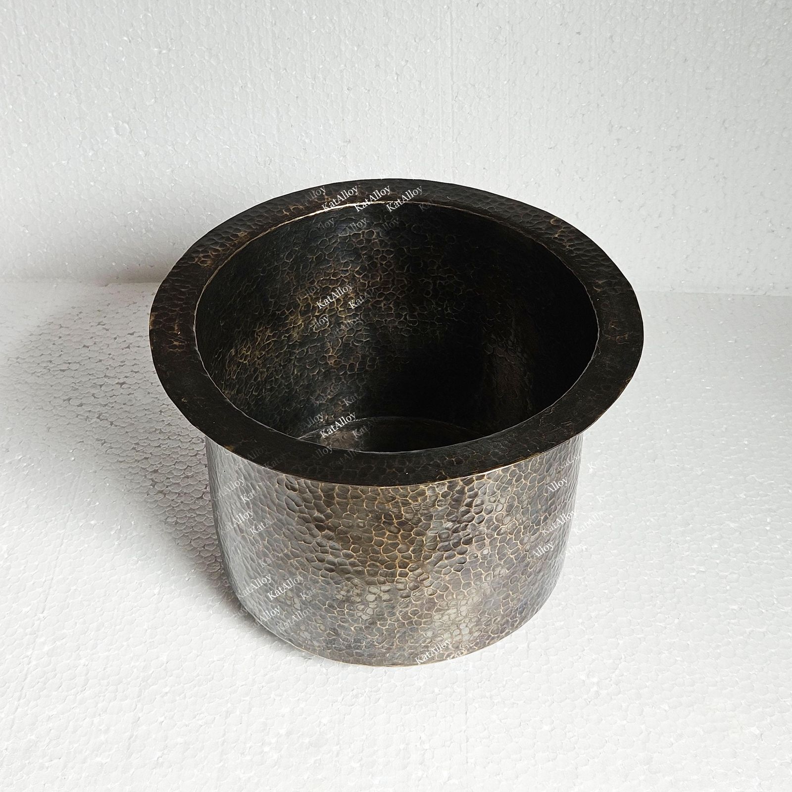 Metallic pot with textured surface on a white background
