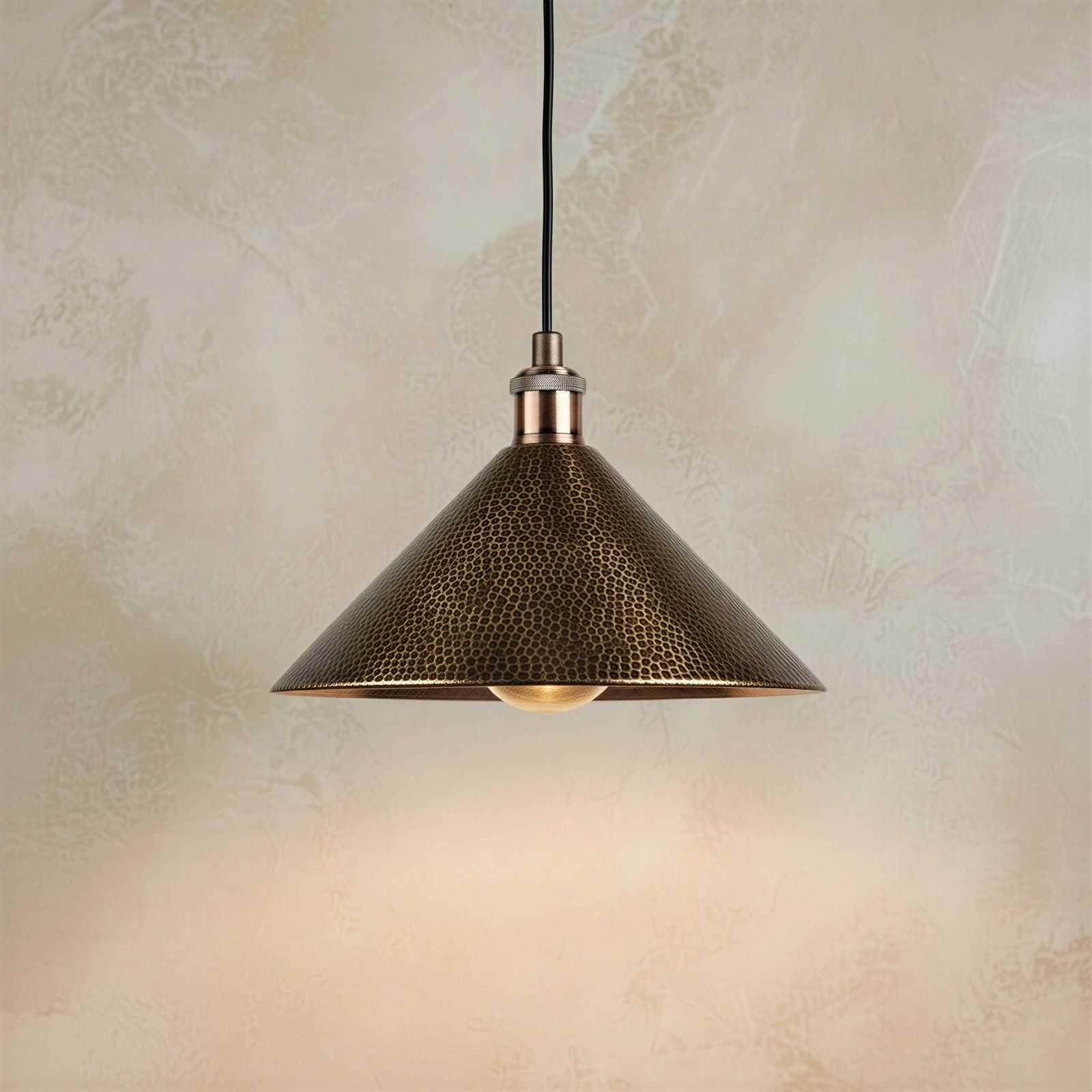 Mid-century modern style hammered metal cone pendant lighting emphasizing the detailed animal-print-like texture on its shade.