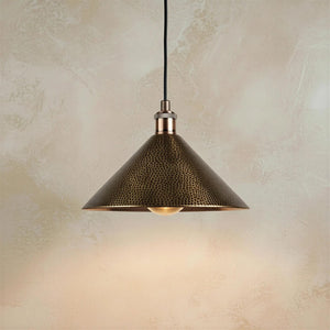 Mid-century modern style hammered metal cone pendant lighting emphasizing the detailed animal-print-like texture on its shade.