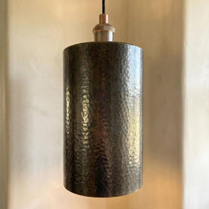 Hammered metal pendant light against a neutral background