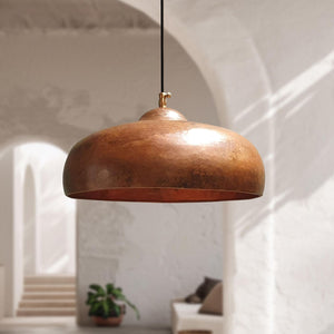 Bronze pendant light hanging in a room with a blurred background