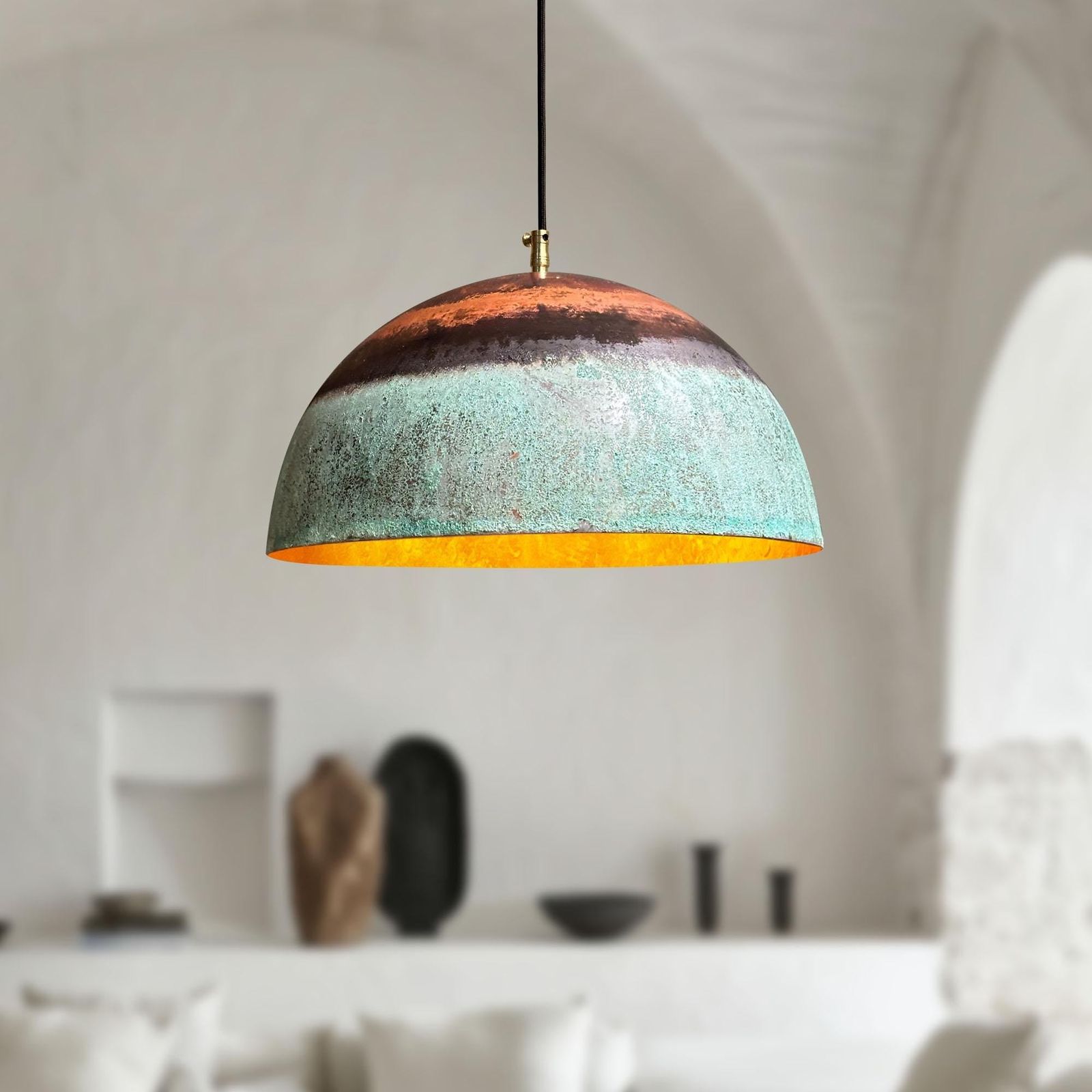 Pendant light with a textured design hanging in a room with neutral decor.