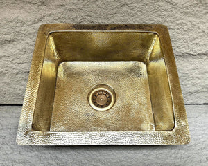 Gold-colored kitchen sink on a stone surface