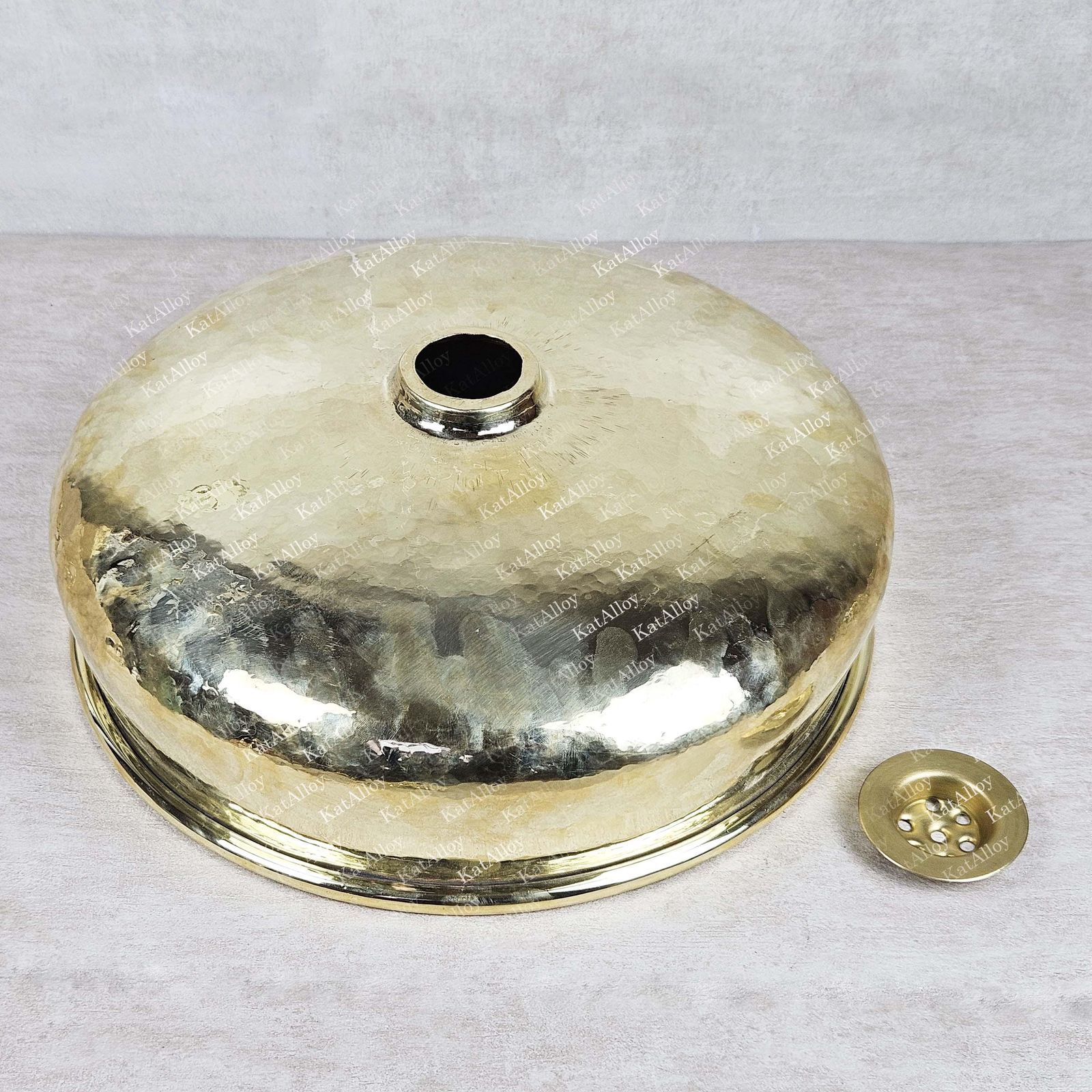 Brass or bronze metal cover with engraved text on a light gray background