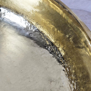 Close-up of a brass instrument with a worn surface on a gray background