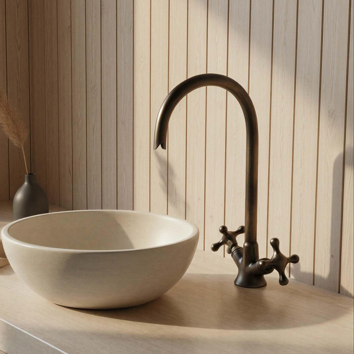 Bathroom sink with a bronze faucet against a wooden panel wall