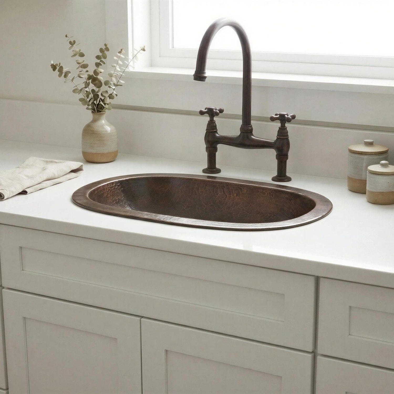brass sink with faucet on a white countertop in a kitchen.