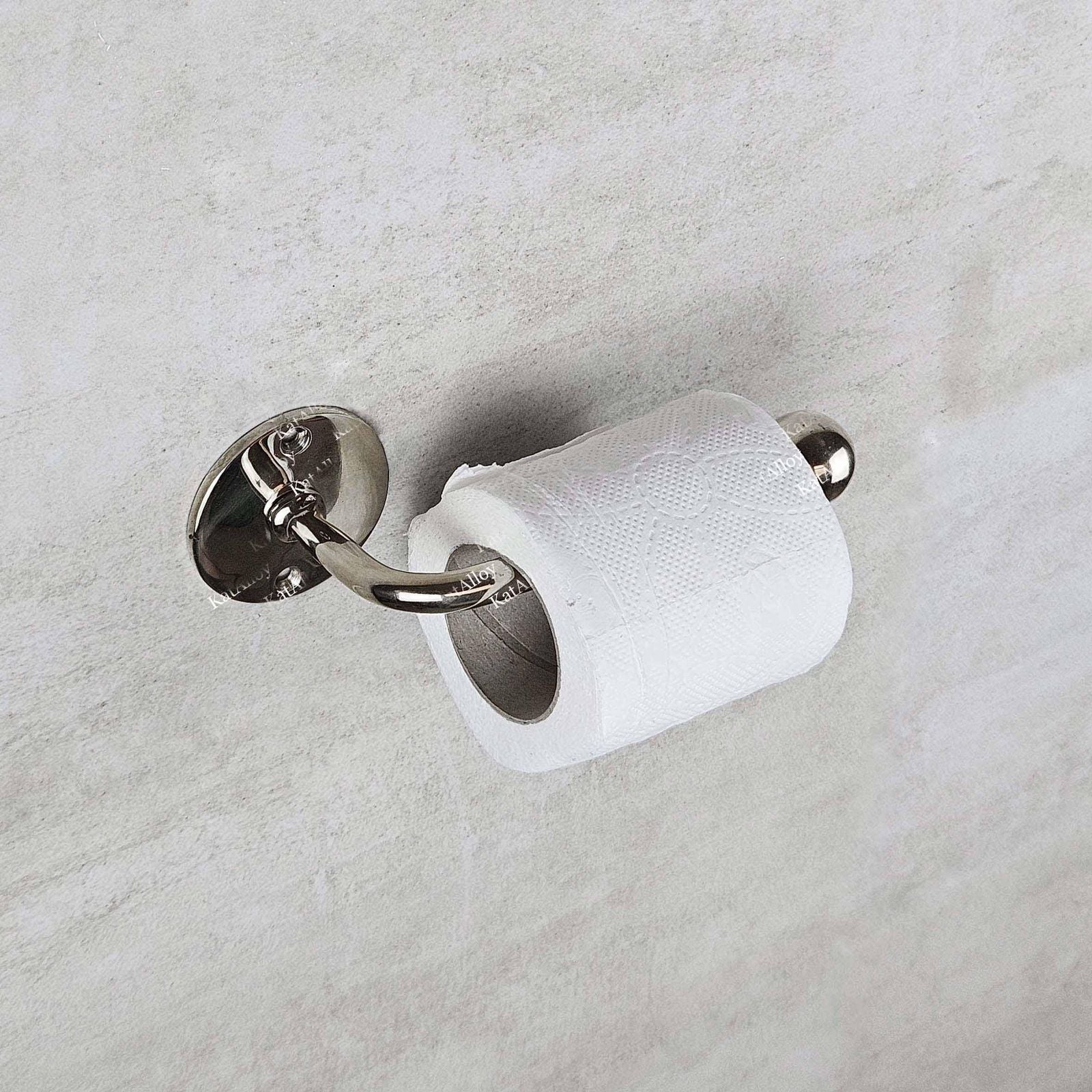 Silver toilet paper holder with a roll of toilet paper on a light gray background