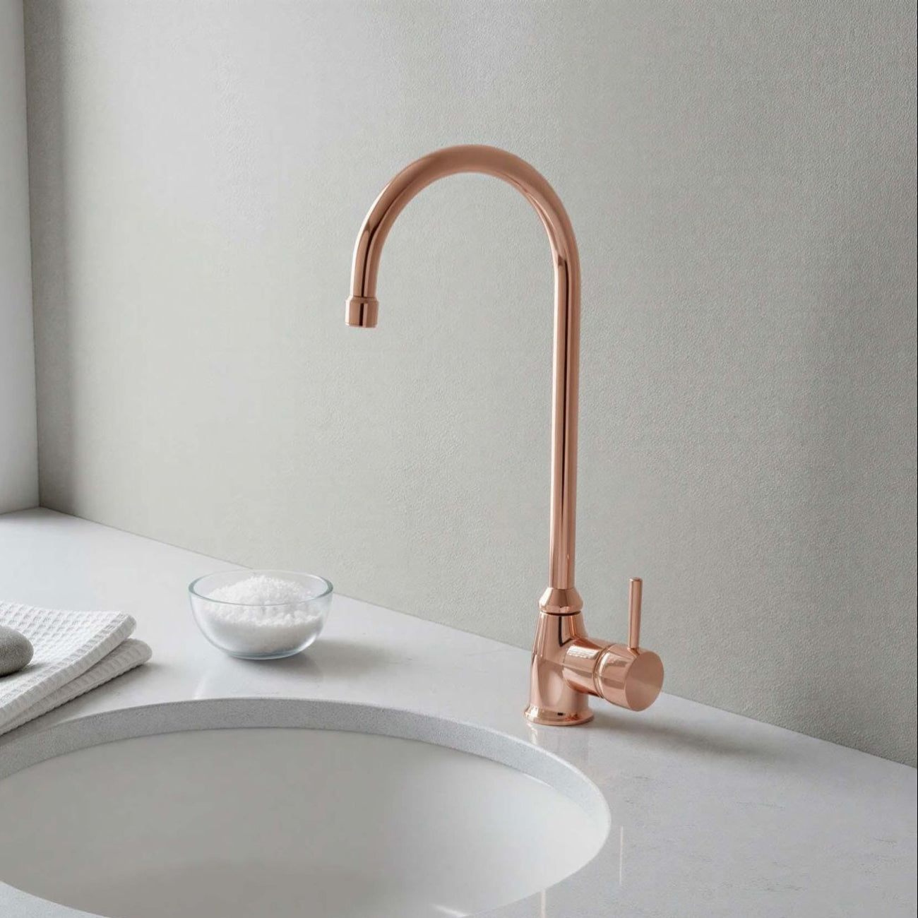 Rose gold faucet on a white sink in a modern bathroom setting