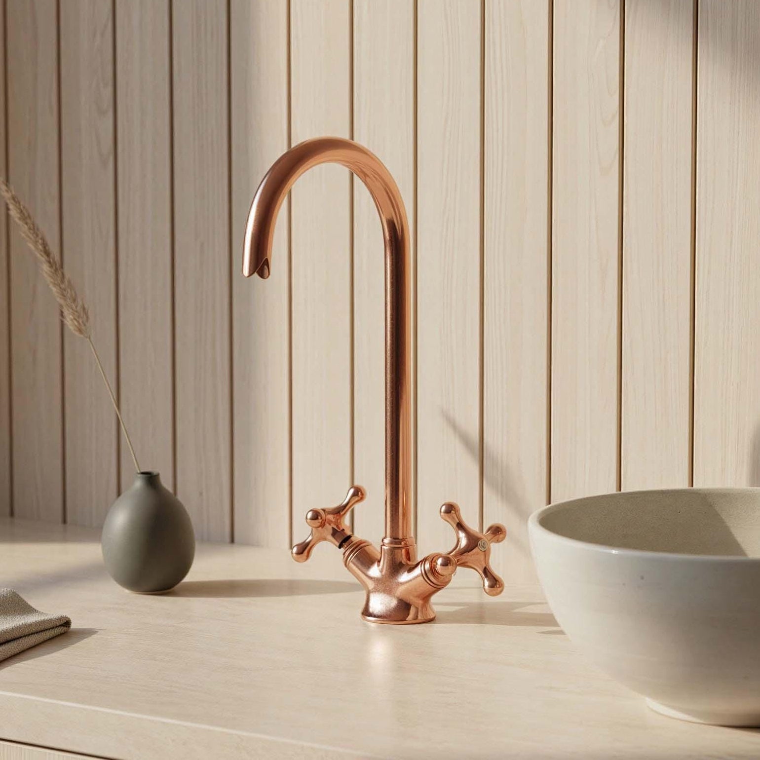 Bathroom setup with a copper faucet and white bowl on a wooden surface.