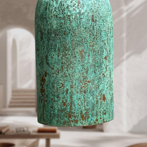 Textured green vase on a blurred indoor background