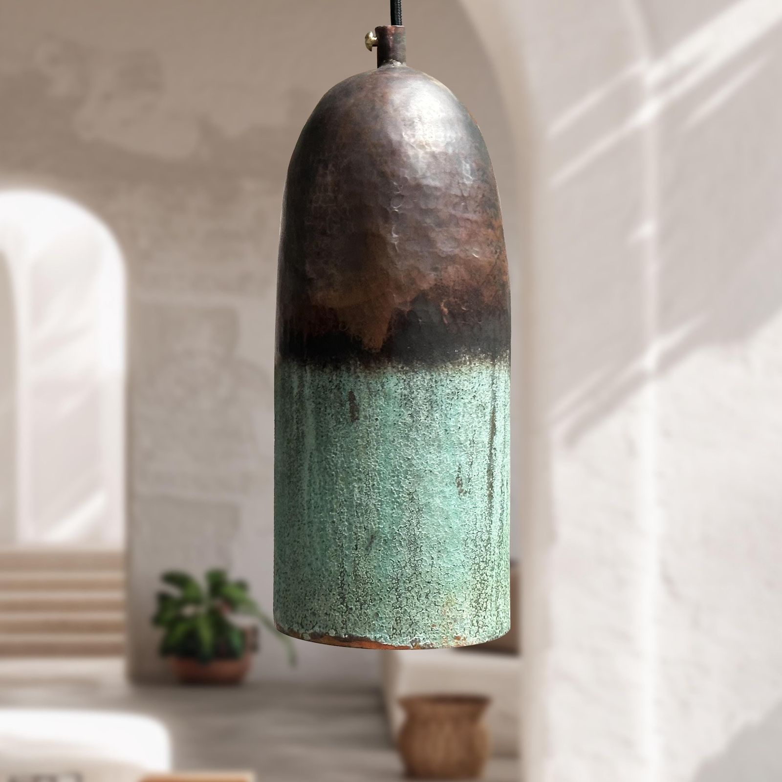 Ceramic pendant light with gradient finish hanging in a softly lit room.