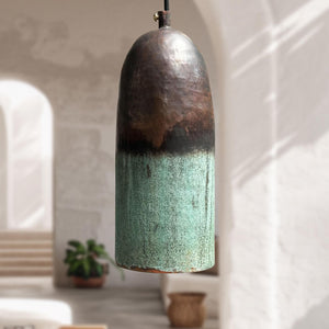 Ceramic pendant light with gradient finish hanging in a softly lit room.