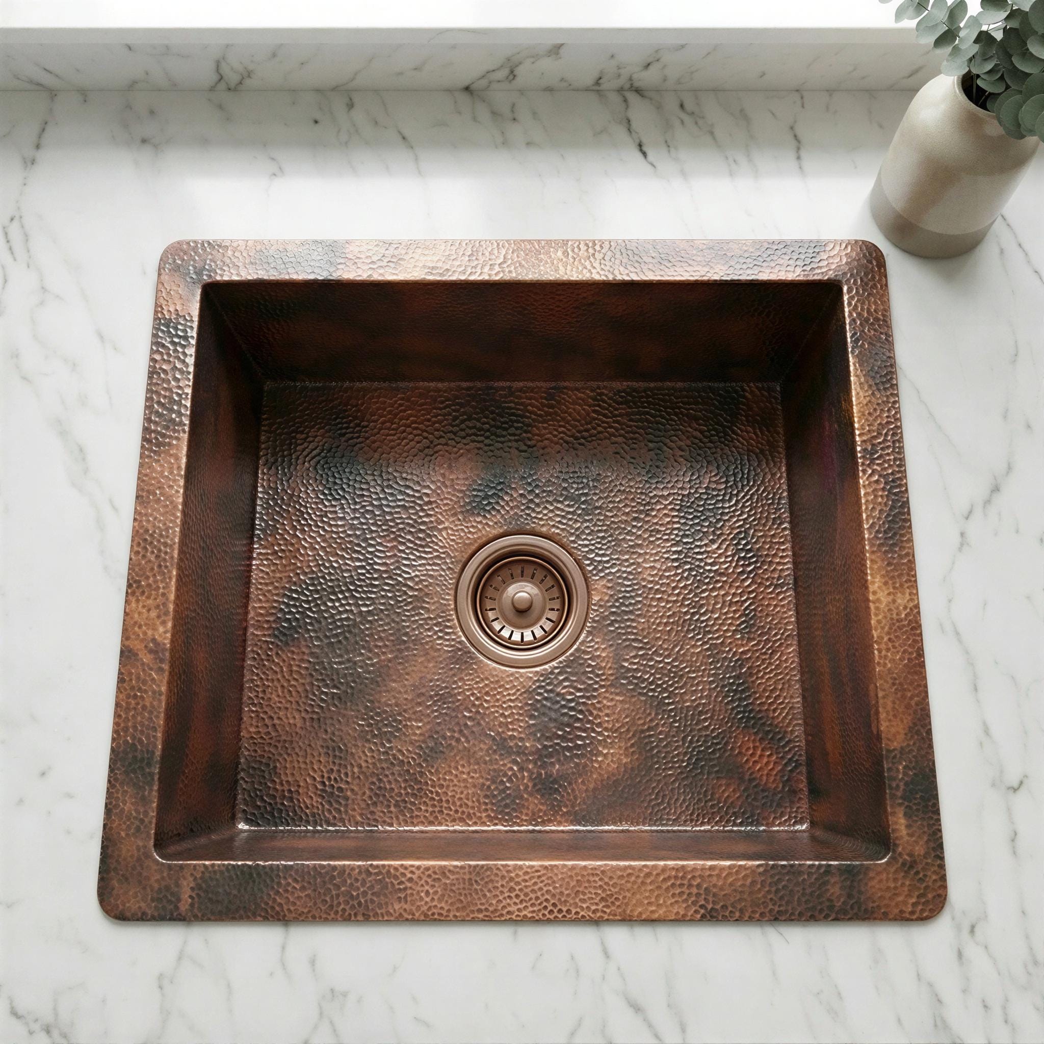 Copper kitchen sink on a marble countertop