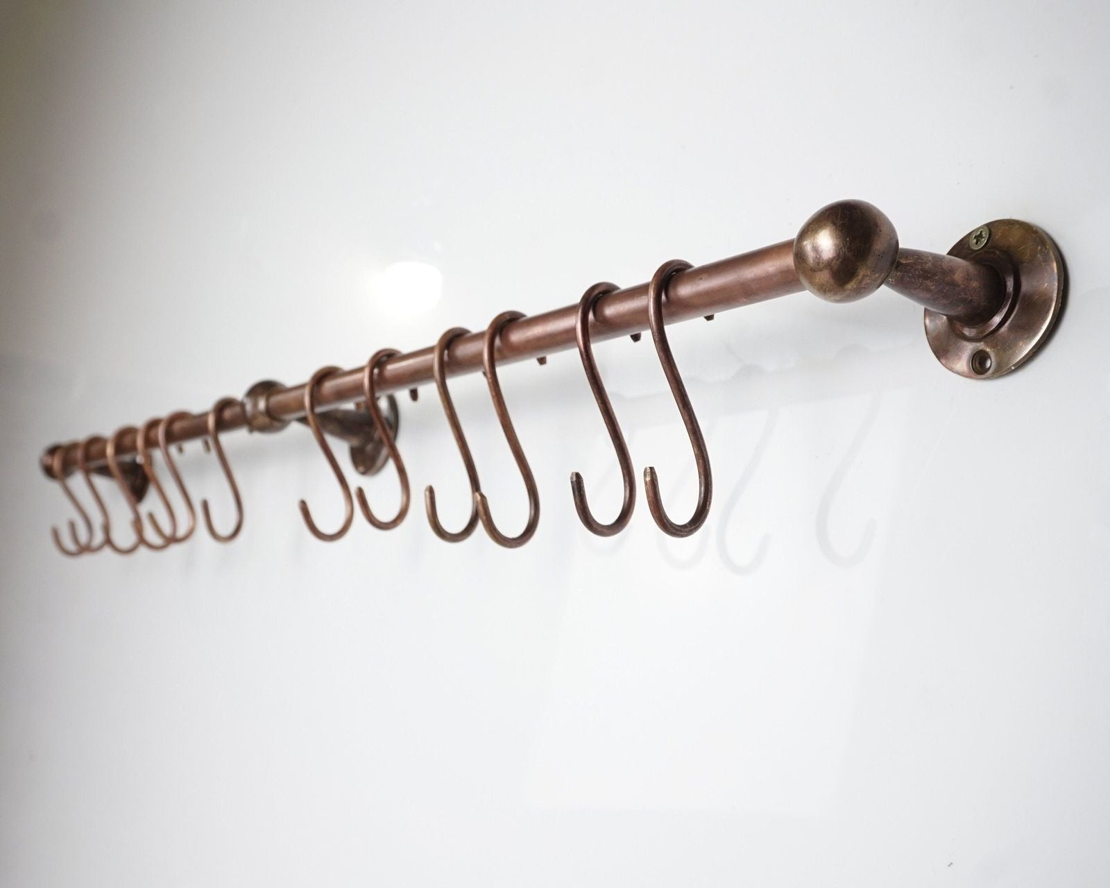 Bronze curtain rod with hooks on a white background
