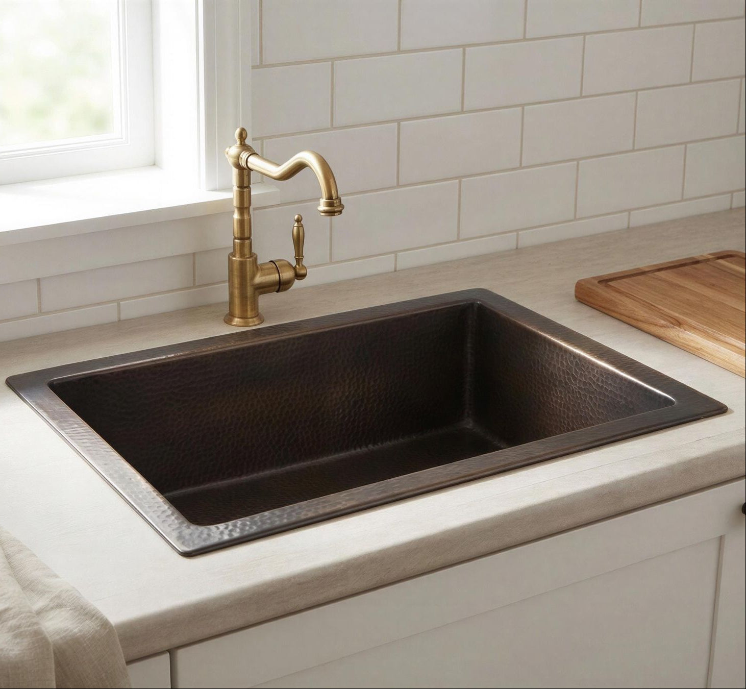 Black kitchen sink with a gold faucet in a modern kitchen setting.