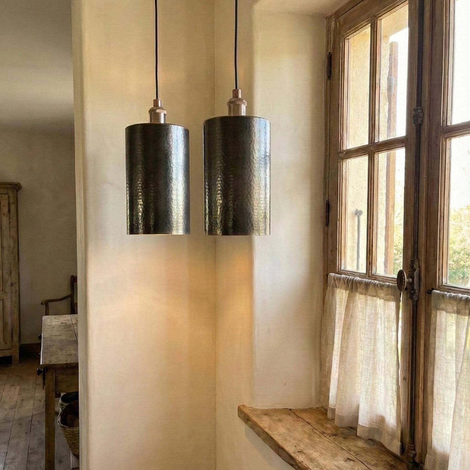 Two pendant lights hanging in a room with a window and wooden shelf.