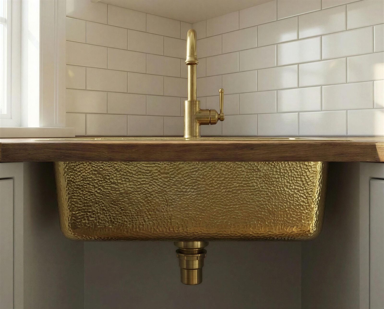 Gold sink with wooden countertop and tiled wall