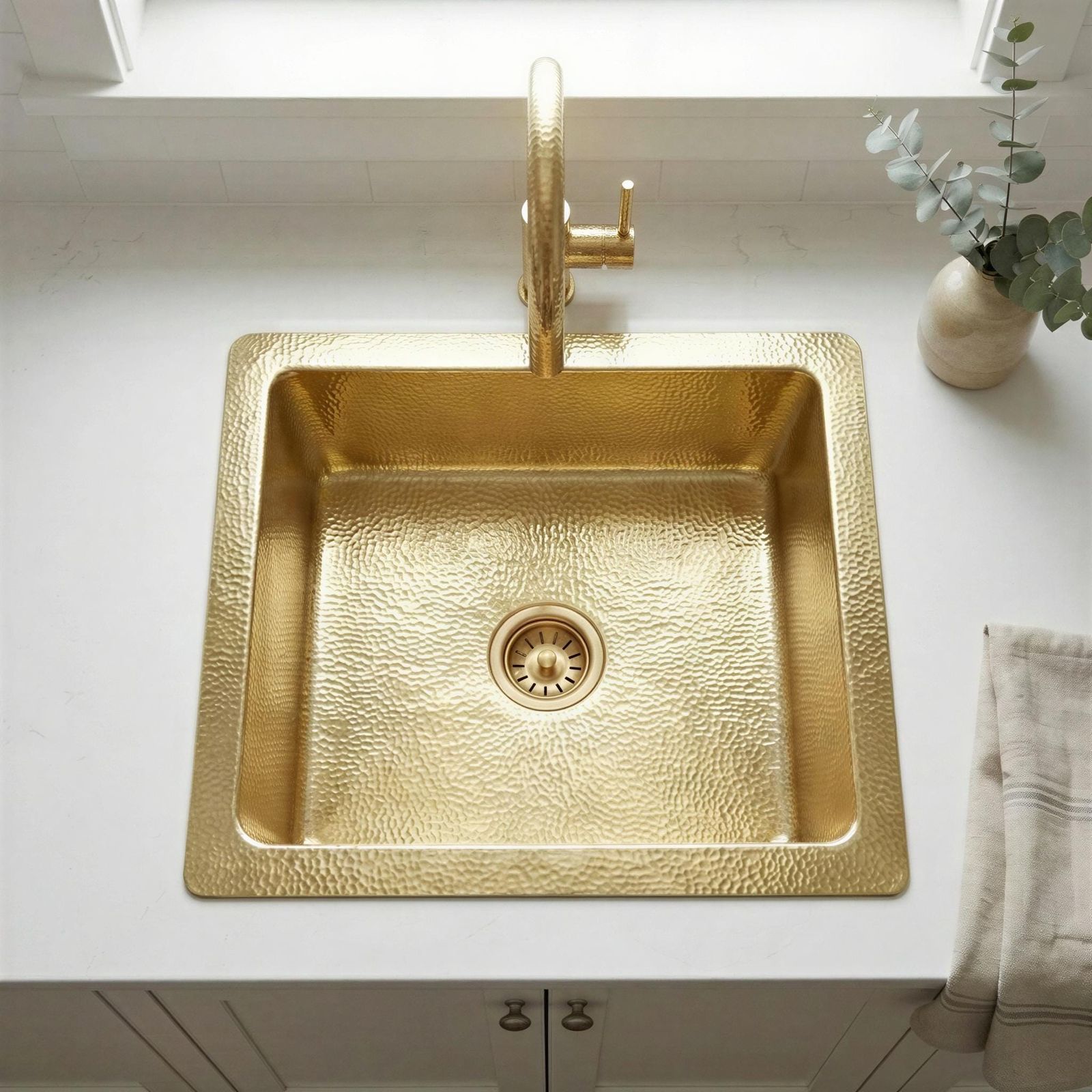 Gold kitchen sink with faucet on a white countertop
