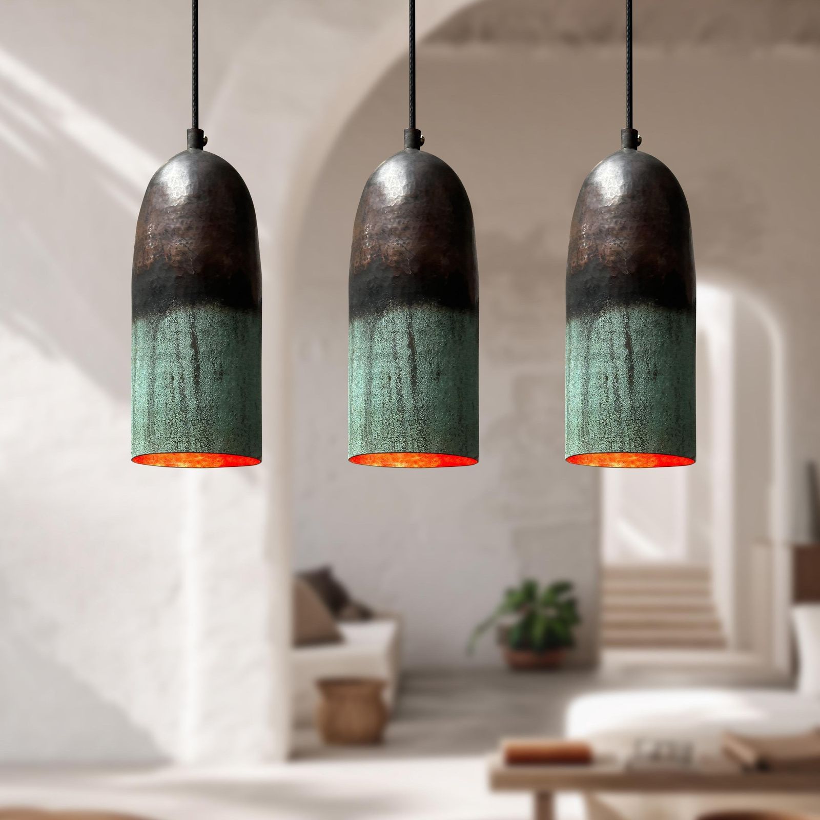 Three pendant lights with a gradient design hanging in a room.