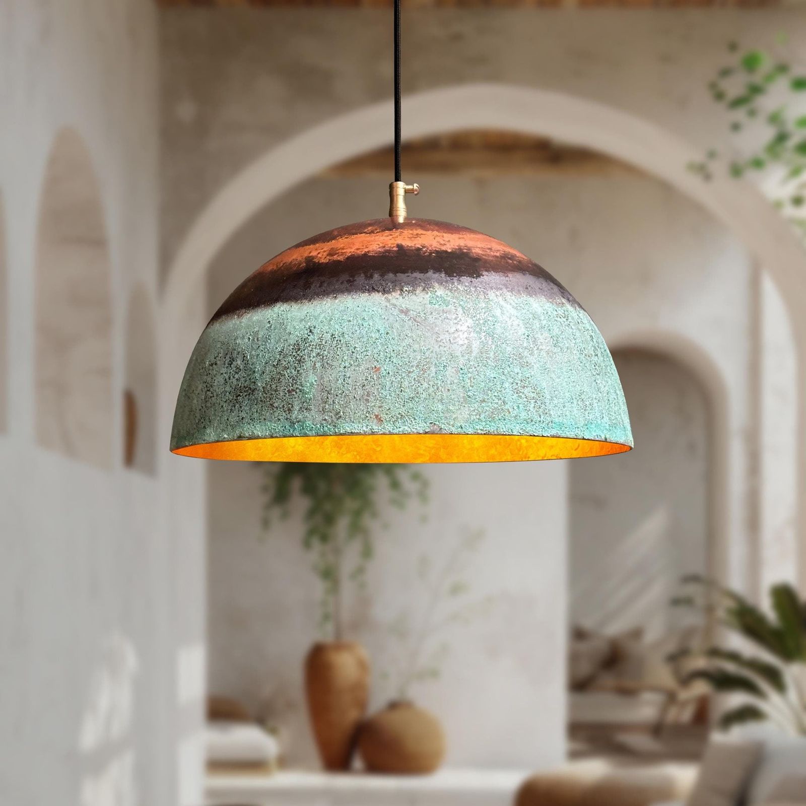 Decorative pendant light with a textured design hanging in a room with plants and arches.