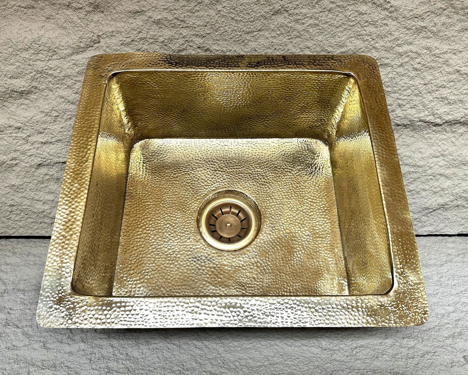 Gold-colored kitchen sink on a stone surface