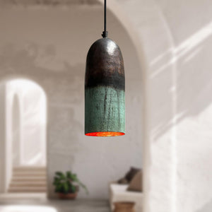 Pendant light with a gradient design hanging in a softly blurred room.