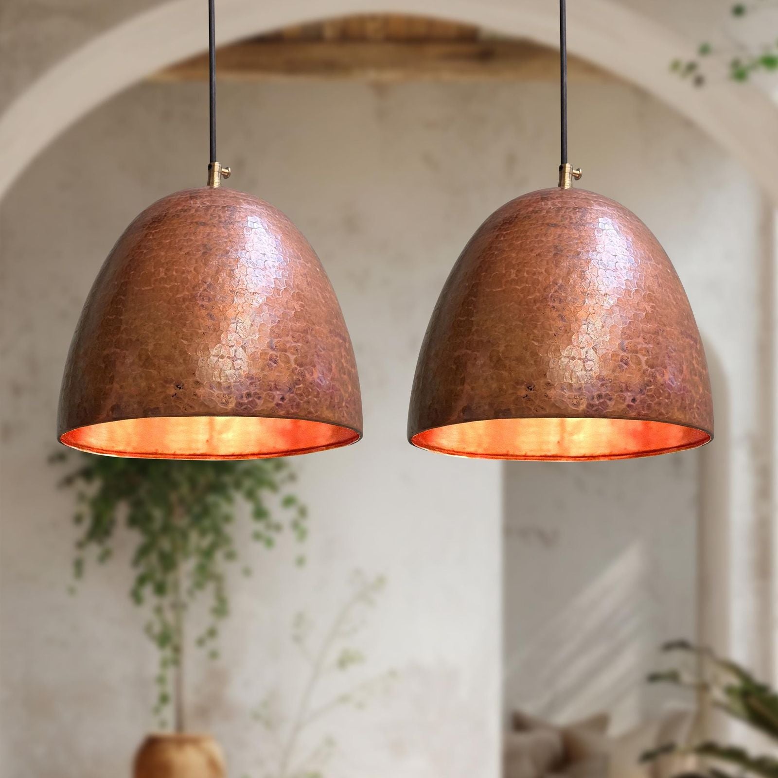 Two copper pendant lights hanging against a neutral background