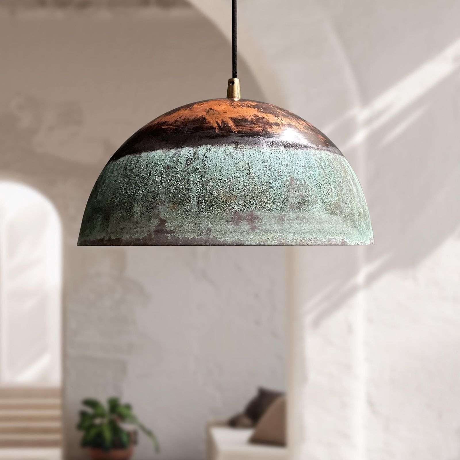 Pendant light with a textured green and brown design hanging in a room.