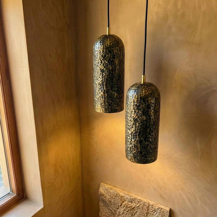 Two hanging pendant lights with textured design on a neutral wall.