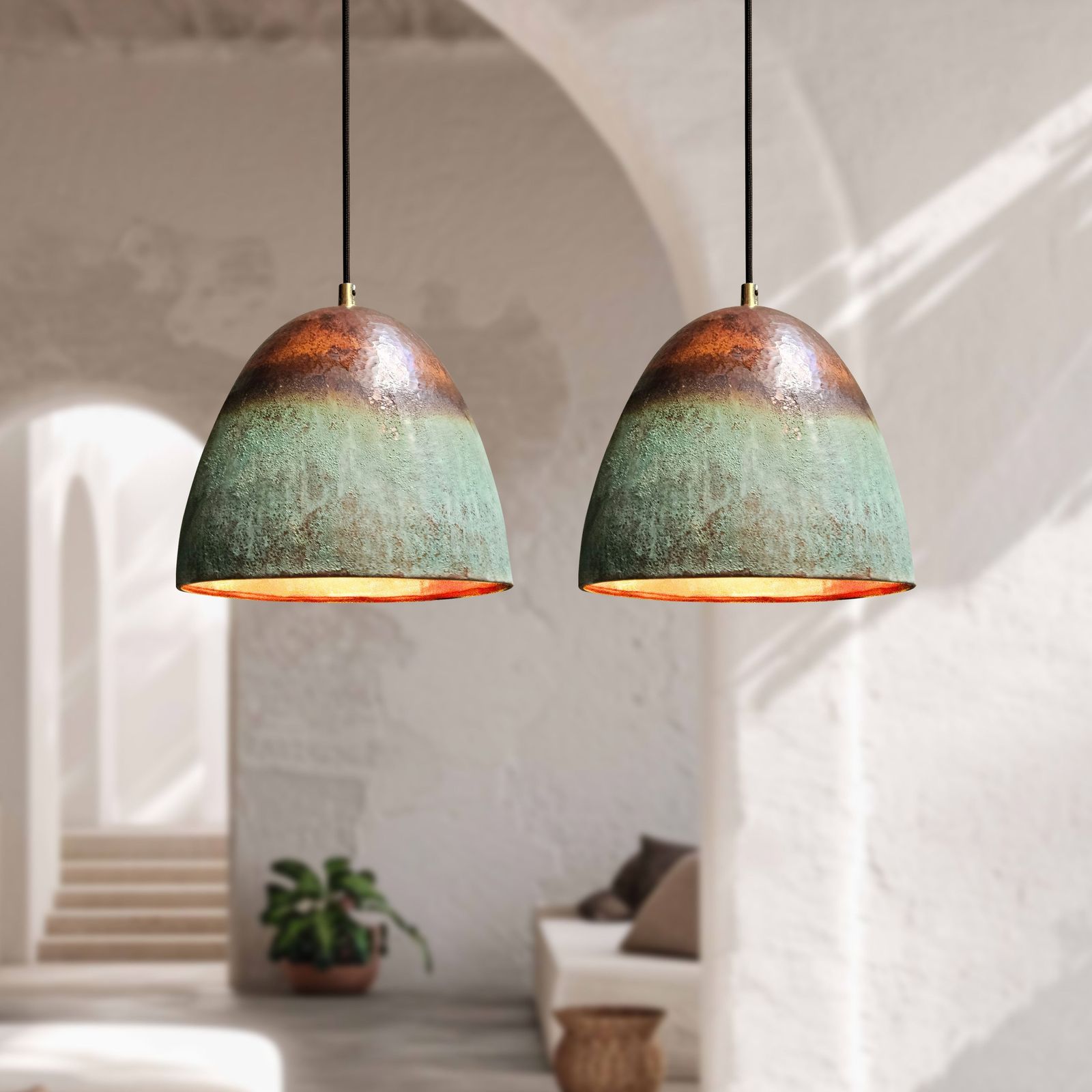 Two rustic pendant lights hanging in a bright room with white walls and minimal decor.