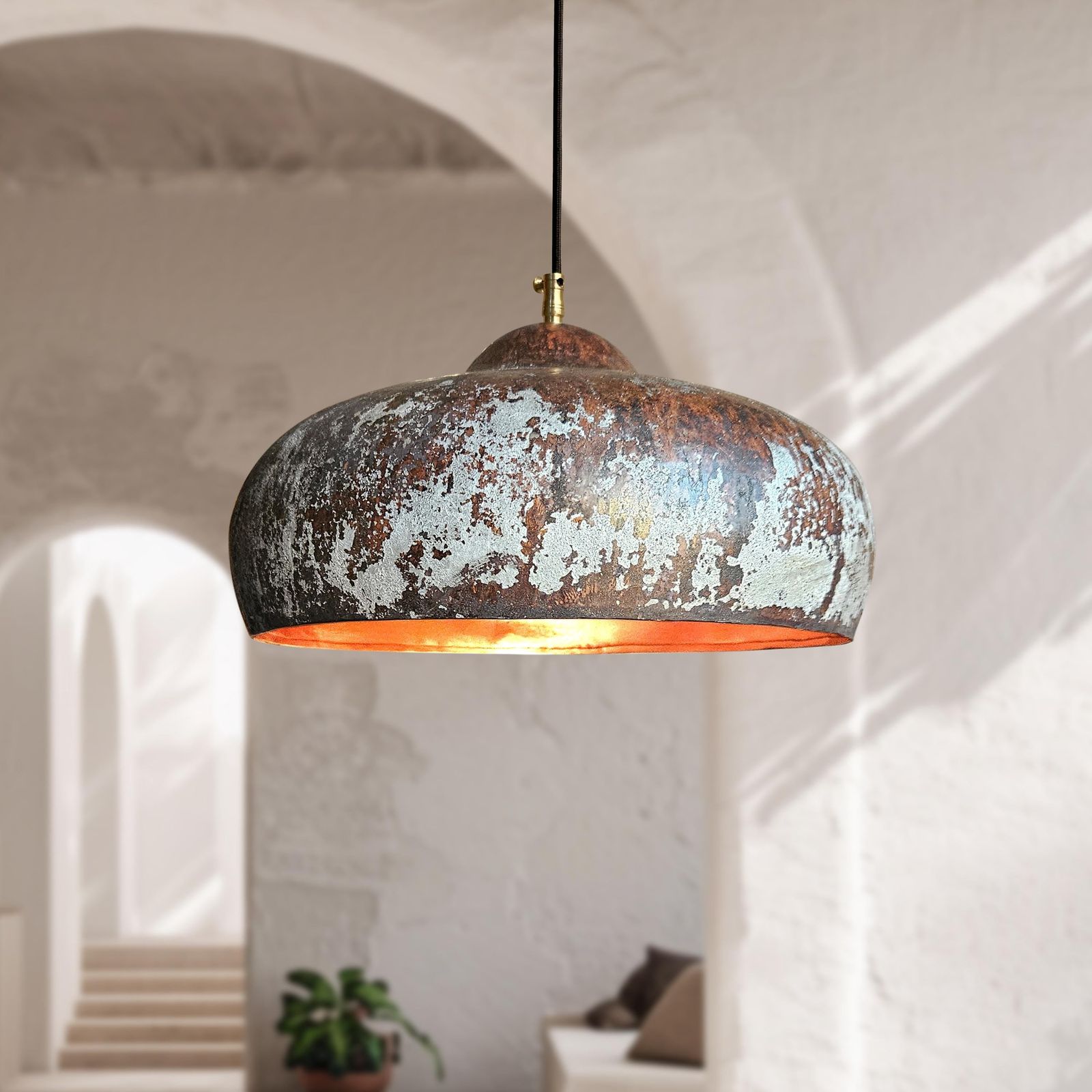 Rustic pendant light hanging in a softly lit room with architectural elements.