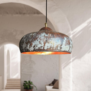 Rustic pendant light hanging in a softly lit room with architectural elements.