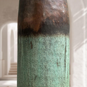 Close-up of a textured cylindrical object with gradient colors on a blurred background