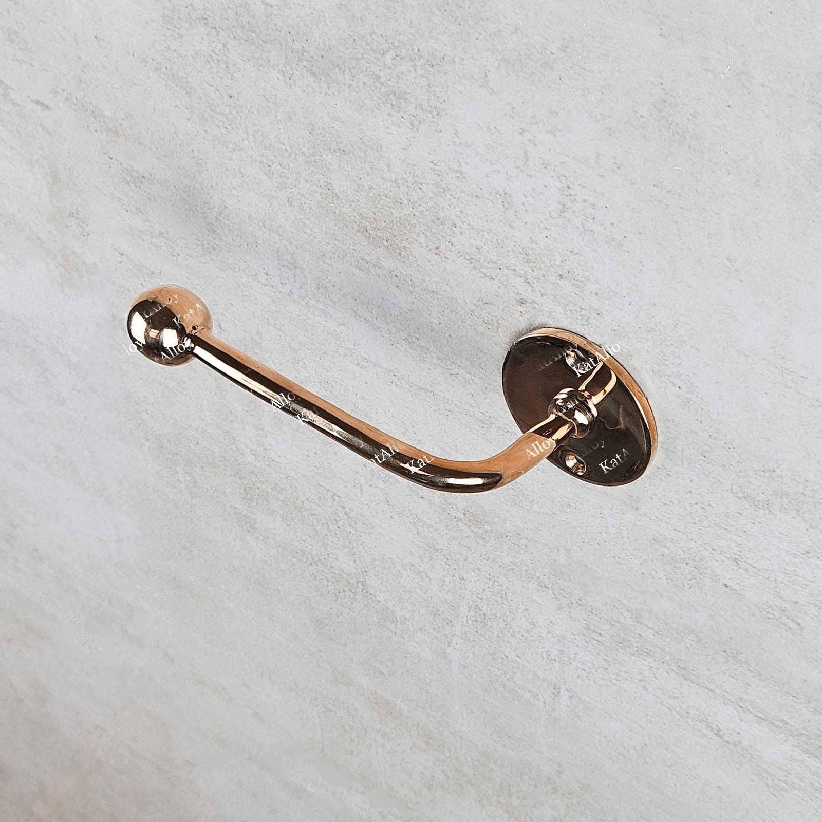 Rose gold towel hook on a light gray background