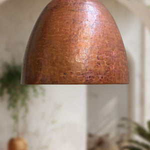 Copper lampshade with a textured surface on a blurred background