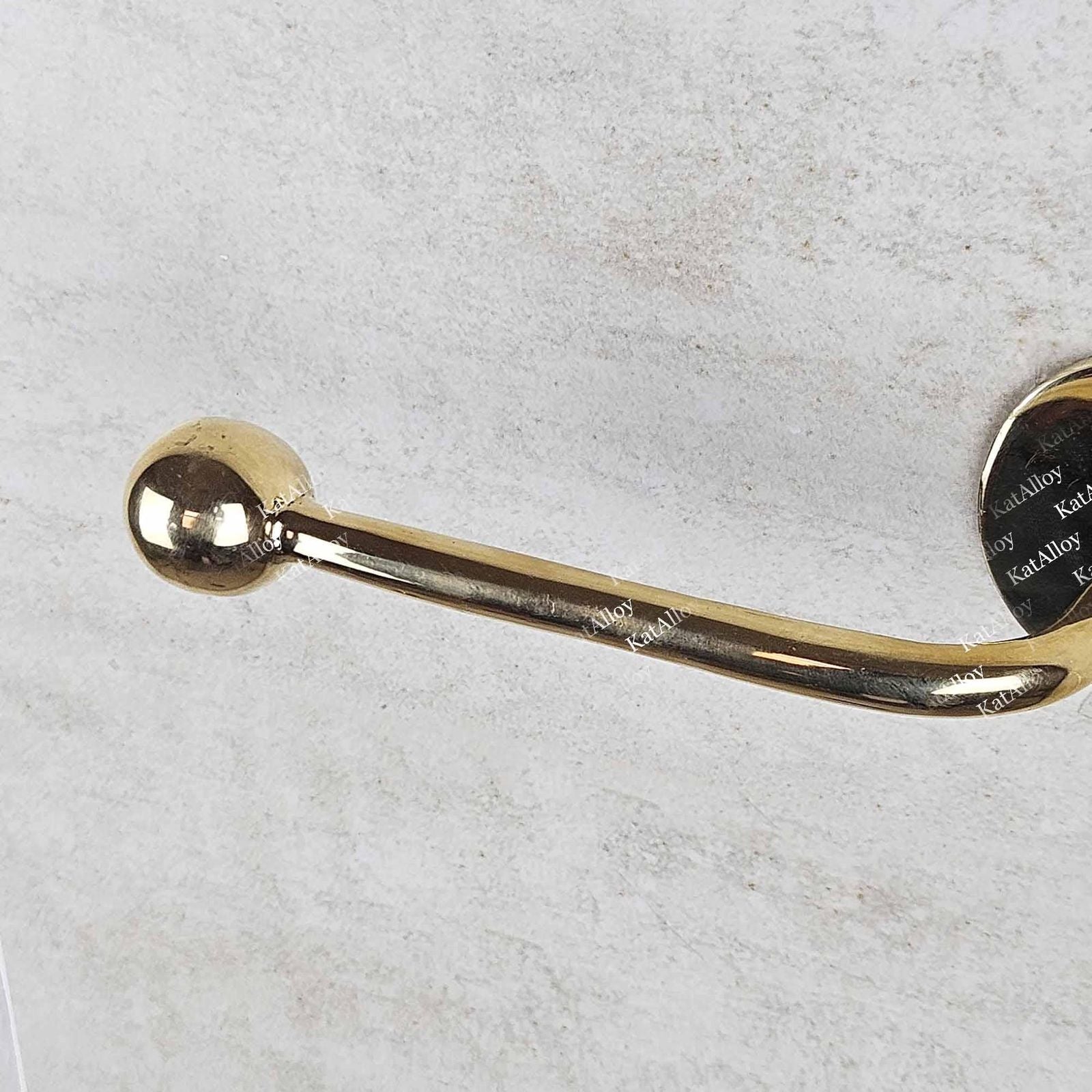 Gold toilet paper holder on a light gray background