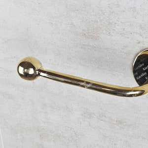 Gold toilet paper holder on a light gray background