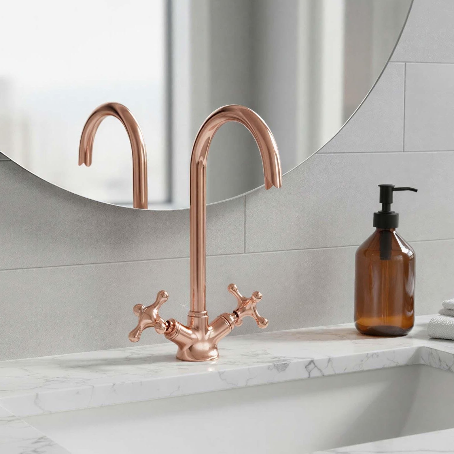 Rose gold faucet on a marble sink with a mirror and soap dispenser in the background.