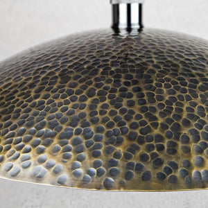 Close-up of a textured metallic lampshade on a light gray background