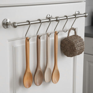 Wooden spoons hanging on a rack with a woven basket in a kitchen setting.