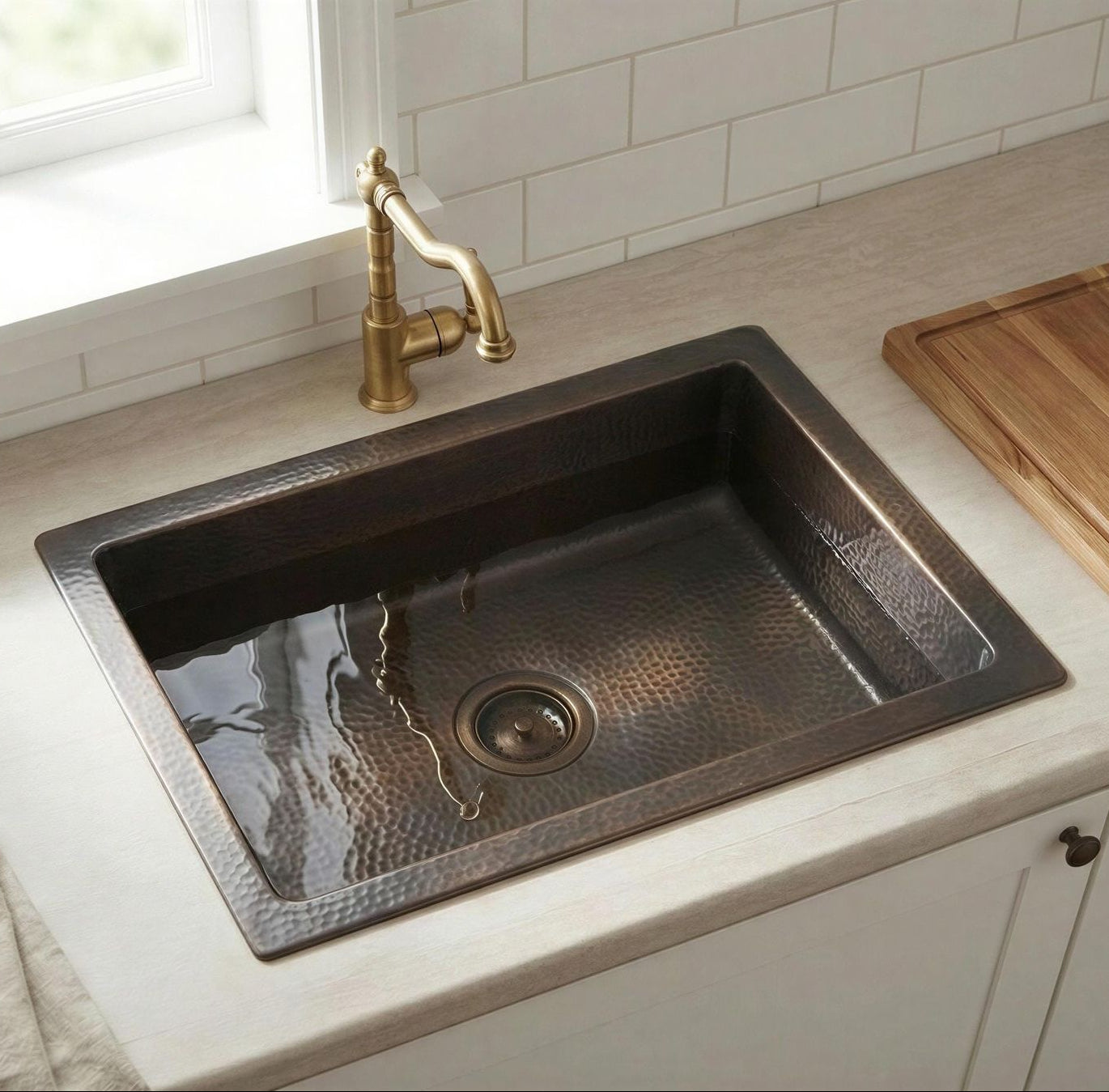 Brass Bronze kitchen sink with gold faucet on a light countertop